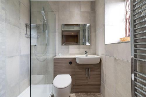 a bathroom with a toilet and a sink and a shower at Briarfields Hotel in Titchwell