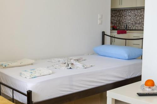 a bed with white sheets and a blue pillow at Duka's House in Lukovë