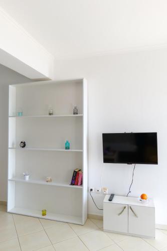 a living room with white shelves and a tv at Duka's House in Lukovë