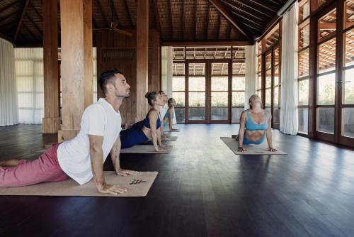 a group of people doing yoga in a room at The Asa Maia - Bespoke Wellness Resort in Uluwatu