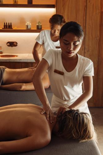 a woman sitting on the floor getting a massage from another woman at The Asa Maia - Bespoke Wellness Resort in Uluwatu