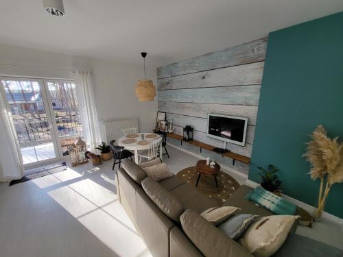 a living room with a couch and a wooden wall at APARTAMENT przy jeziorze in Borne Sulinowo