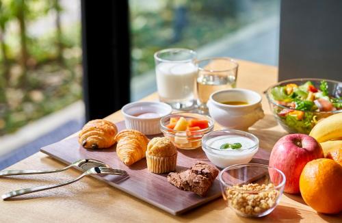 a table with breakfast foods and drinks on it at Tassel Hotel Sanjo Shirakawa in Kyoto