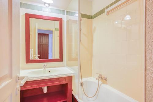 une salle de bain avec un lavabo, une baignoire et un miroir dans l'établissement Le Domaine de Gascogne - appartement 2 pièces 4/5 personnes, à Biscarrosse