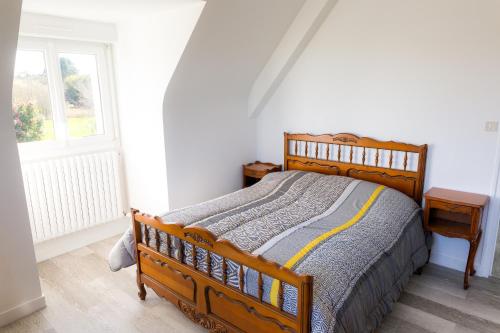 une chambre avec un lit en bois et une fenêtre dans l'établissement Jolie maison pour 10 personnes avec jardin, à Plobannalec-Lesconil