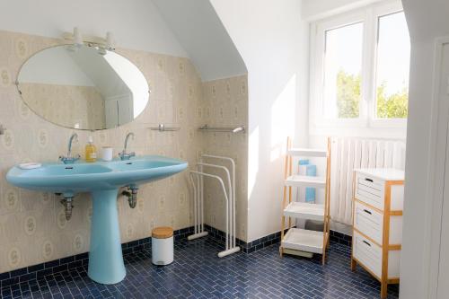 une salle de bain avec un lavabo bleu et un miroir dans l'établissement Jolie maison pour 10 personnes avec jardin, à Plobannalec-Lesconil
