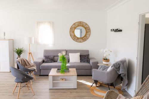 ein Wohnzimmer mit einem Sofa und einem Tisch in der Unterkunft Jolie maison pour 8 personnes in Plobannalec-Lesconil