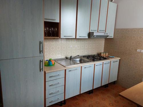 a small kitchen with white cabinets and a sink at SALENTO VACANZE in Villanova di Ostuni