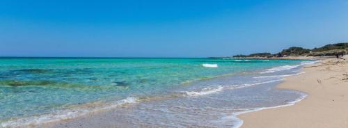 a beach with turquoise water and the ocean at SALENTO VACANZE in Villanova di Ostuni