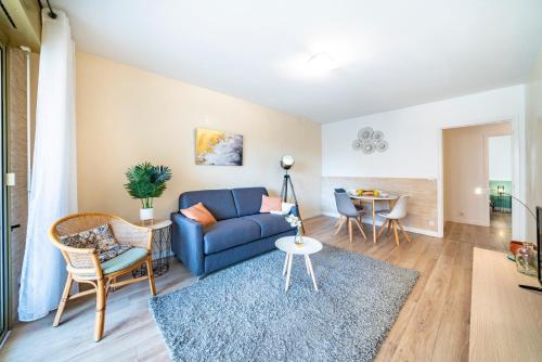 un salon avec un canapé bleu et une table dans l'établissement 50m Monaco - Grimaldi forum - Larvotto Beach - AI, à Beausoleil