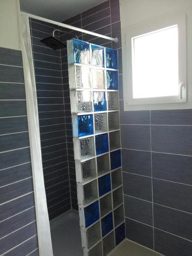 une douche avec du carrelage bleu en verre et une fenêtre dans l'établissement la belle bleue, à Banyuls-sur-Mer