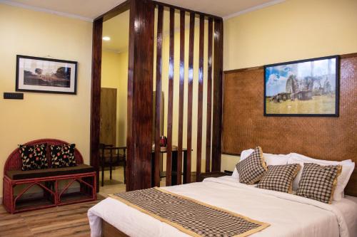 1 dormitorio con 1 cama grande y 1 silla en The Arcadia Resort - Umroi, en Shillong