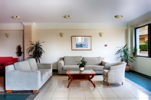 a living room with two couches and a coffee table at Alkionides Seaside Hotel in Plataniás