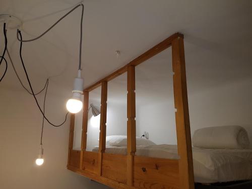 - un miroir dans une chambre avec un lit et une lampe dans l'établissement Charmant studio tout équipé au coeur d Avignon, à Avignon