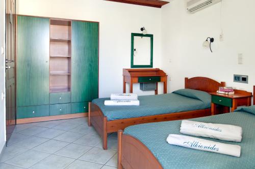 a room with two beds and a desk and a mirror at Alkionides Seaside Hotel in Plataniás