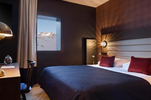 a hotel room with a large bed with a window at Hôtel Marielle in Val Thorens