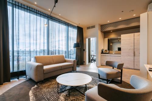 a living room with a couch and chairs and a table at Tallink City Hotel in Tallinn