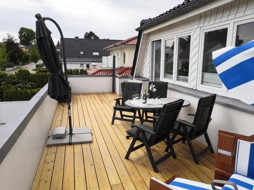 a deck with a table and chairs and an umbrella at Haus Lackner in Timmendorfer Strand