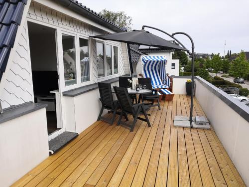 a deck with a table and chairs and an umbrella at Haus Lackner in Timmendorfer Strand