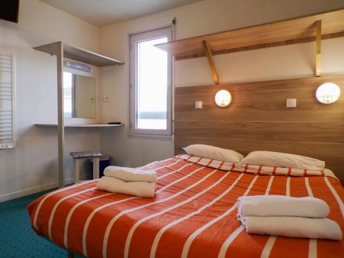 卓奈克蘭的住宿－普瓦捷未來世界法斯特酒店，一间卧室配有一张大床和毛巾