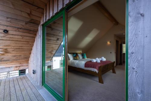 a bedroom with a bed and a glass door at Shore Cottage Isle of Skye in Portree