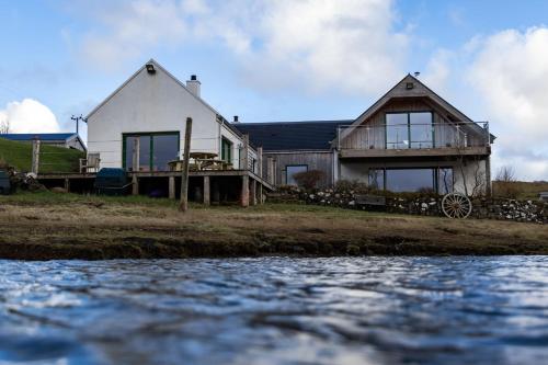 a house on the shore of a body of water at Shore Cottage Isle of Skye in Portree