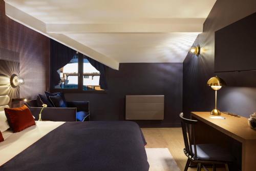 a bedroom with a bed and a desk in a room at Hôtel Marielle in Val Thorens