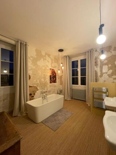 łazienka z wanną i 2 umywalkami w obiekcie Maison Dada et SPA w mieście Meyssac