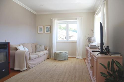 a living room with a couch and a window at Casal de São José - Peaceful Country House near Mafra and Lisbon - Garden, Space and Comfort in Mafra