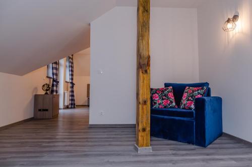 a blue couch with two pillows in a room at Hotel Do Poduchy in Zawiercie