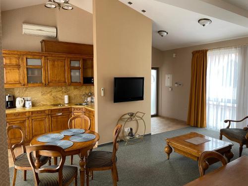 a kitchen and a living room with a table and a dining room at Apartment Senamiesčio Inkaras in Klaipėda