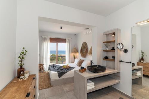 a living room with a bed and a window at Luxury NissoVilla with Private Pool & Sea Views in Kolimbia