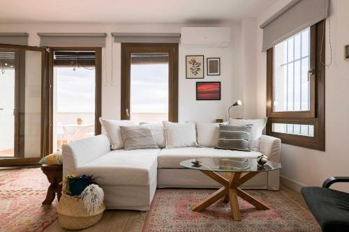 uma sala de estar com um sofá branco e uma mesa em Casa Alvar em Vejer de la Frontera