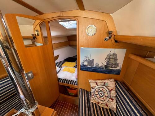 Habitación pequeña con cama y foto de un barco en Barca a vela sul lago Maggiore en Locarno