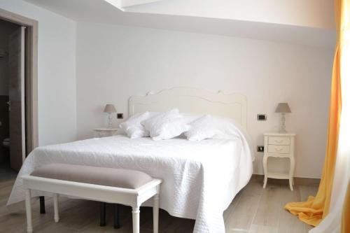 a white bedroom with a white bed and a white chair at B&B Cloud in Santa Maria Capua Vetere