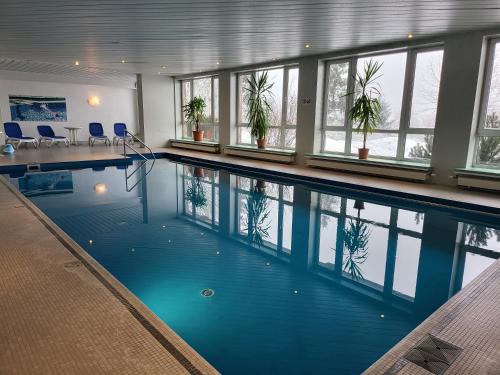 ein Pool mit Pflanzen in einem Gebäude in der Unterkunft Werrapark Resort Hotel Frankenblick in Masserberg