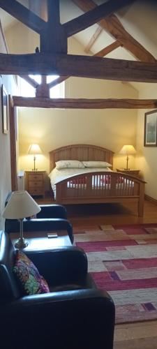 a bedroom with a bed and couches in a room at Henllys Estate B and B in Llandovery