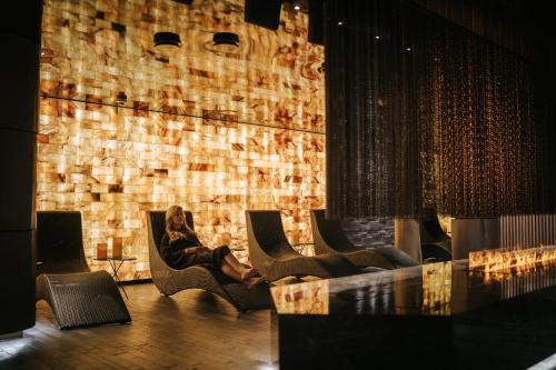 a man sitting in chairs in a room with a fireplace at Tallink City Hotel in Tallinn