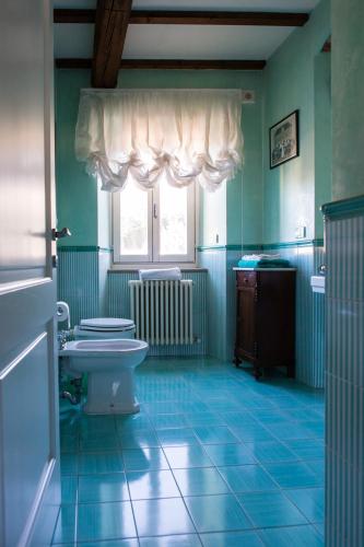 a bathroom with a toilet and a sink and a window at In Palazzo Storico tra Firenze Bologna e Ravenna in Marradi