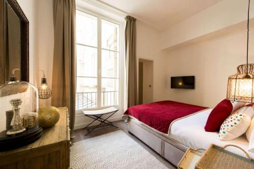 une chambre avec un lit et une grande fenêtre dans l'établissement Rue Charlot Le Marais, à Paris