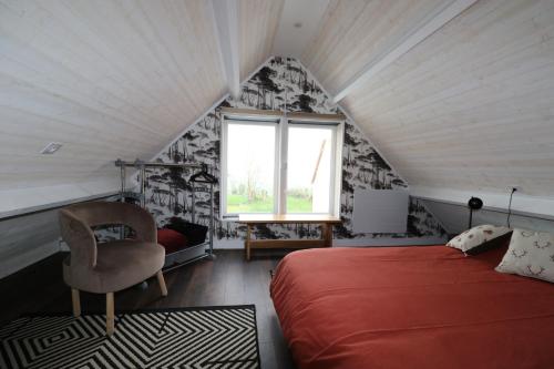 a bedroom with a red bed and a window at Chambre d'hôtes Boutteville in Boutteville