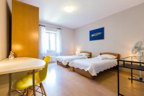 Pokój szpitalny z dwoma łóżkami i stołem w obiekcie Quattro Cantoni Apartments w mieście Zadar