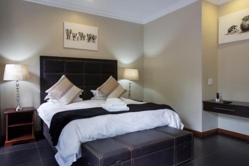 a bedroom with a large bed with a black headboard at Buffalo Brooke in Hectorspruit