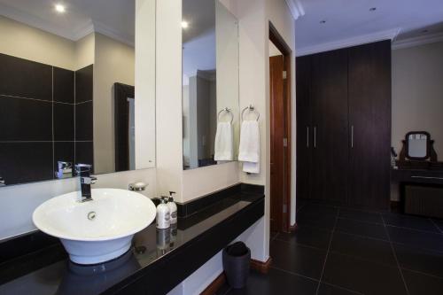 a bathroom with a sink and a large mirror at Buffalo Brooke in Hectorspruit