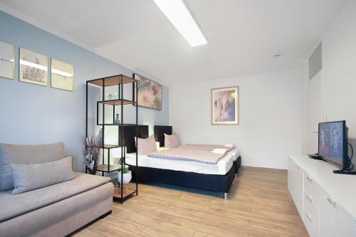 ein Schlafzimmer mit einem Bett und einem Sofa in einem Zimmer in der Unterkunft Eddy's Rest & Relax - Munich East in München