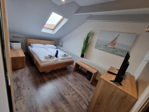 a small room with a bed and a tv in it at Sleeping Sailors Boutique Hotel in Siófok