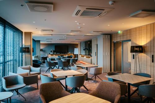 a restaurant with tables and chairs and a bar at Tallink City Hotel in Tallinn