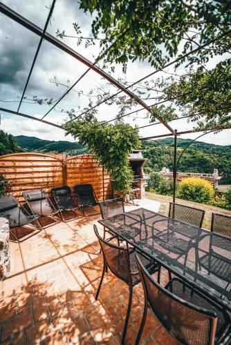 a table and chairs on a patio with a view at La Ferme du Vallon by ExplorHome in Labatie-dʼAndaure