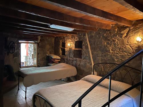 a bedroom with three beds in a room with a stone wall at Rodous Village House in Limassol