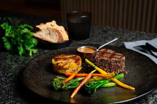 a plate of food with meat and vegetables on a table at Tallink City Hotel in Tallinn
